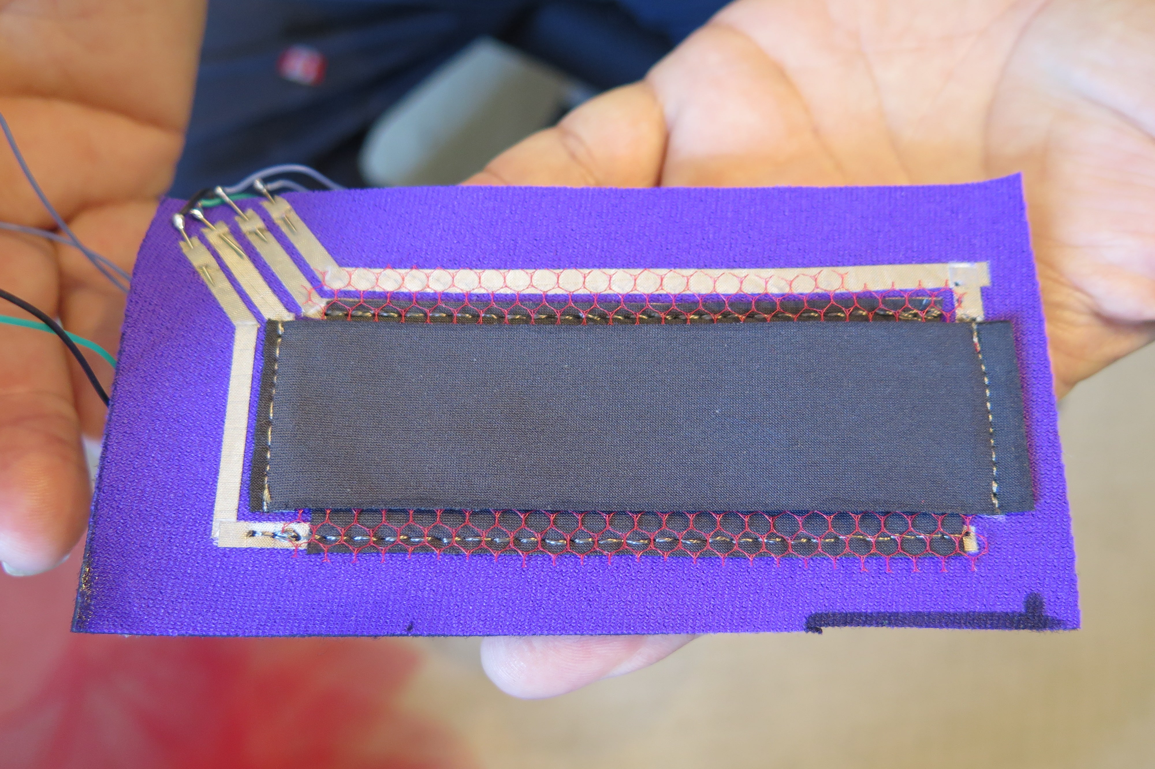 fabric based touchpad using two pieces of piezoresistive fabric, ironed-on conductive fabric and nylon netting. 